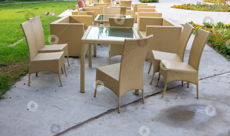 Скачать Стеклянные столы и плетеные стулья в кафе на открытом воздухе фотосток Ozero