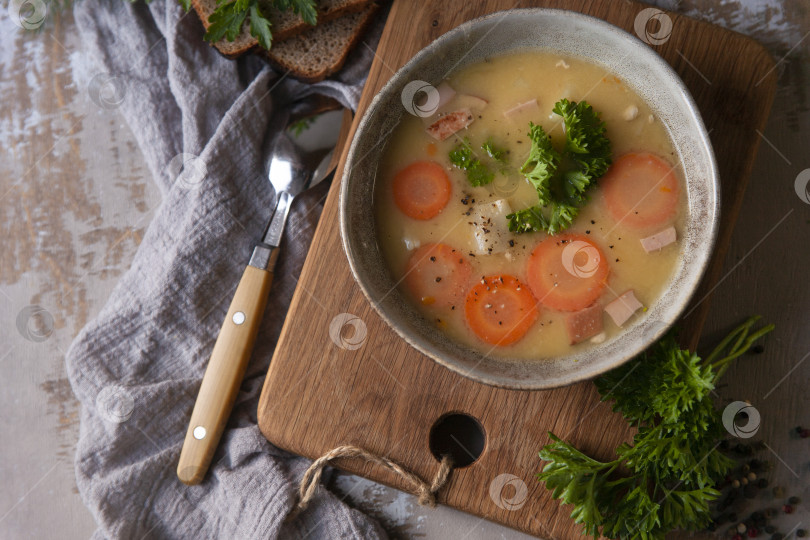 Скачать Свежий гороховый суп-пюре домашнего приготовления со свежей петрушкой на кухне в деревенском стиле, плоская подача, место для копирования фотосток Ozero