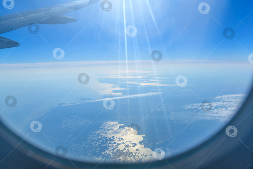 Скачать Вид с высоты птичьего полета на Астраханскую область, Россия, не в фокусе, если смотреть с самолета с передним крылом. Солнечные лучи, блики. фотосток Ozero