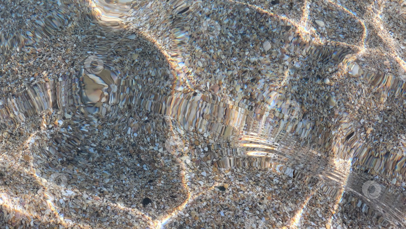 Скачать Морское песчаное дно просматривается сквозь прозрачную бирюзовую морскую воду. Солнечные блики на поверхности моря. Красивый абстрактный фон. Пространство для копирования. Избирательный фокус фотосток Ozero