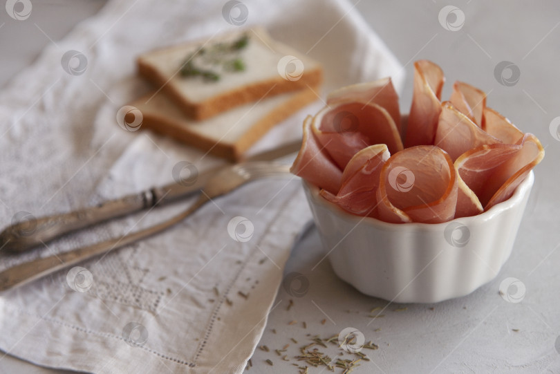 Скачать Вяленое мясо в белой тарелке с двумя ломтиками пшеничного хлеба. фотосток Ozero