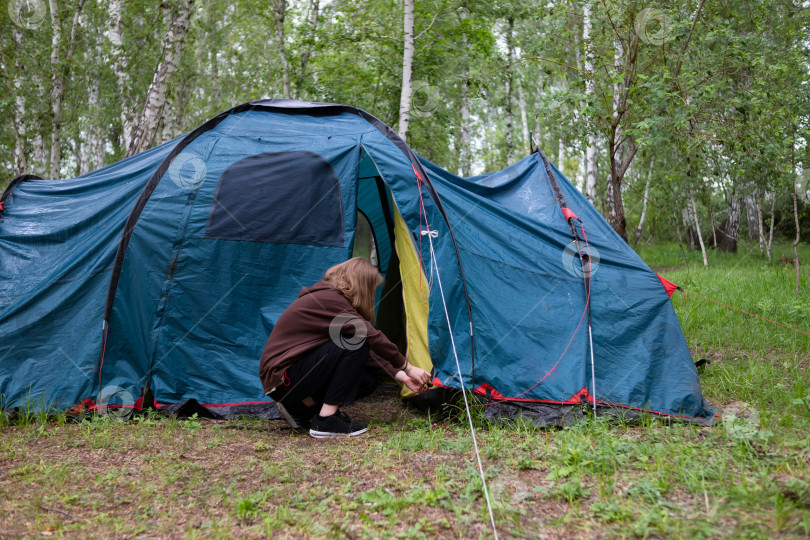 Скачать Женщина ставит палатку в лесу. Путешествия. фотосток Ozero