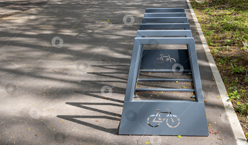 Скачать Велосипедная стойка в парке на стоянке в ясный солнечный день фотосток Ozero