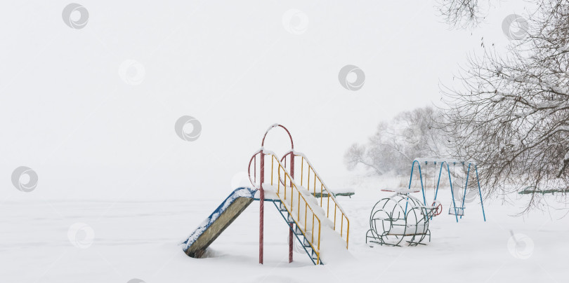 Скачать Детская площадка, покрытая снегом фотосток Ozero