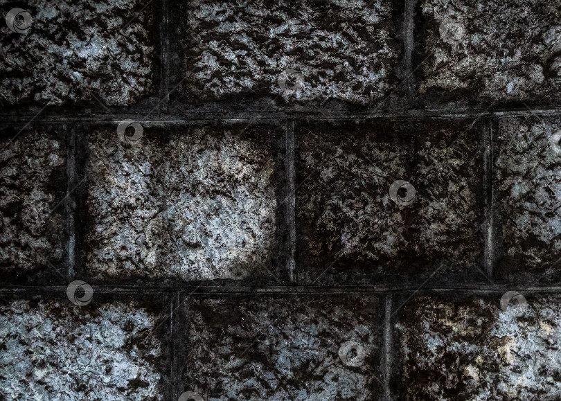 Скачать Грубая текстура каменной кладки, сфотографированной крупным планом. Поверхность кладки покрыта темным налетом. фотосток Ozero