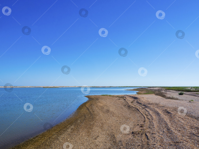 Скачать Живописный прибрежный пейзаж нетронутой природы с песчаным пляжем под голубым небом. Вид на море с дикой природой морской лагуны с песчаными отмелями и бухтами на фоне ясного голубого неба фотосток Ozero
