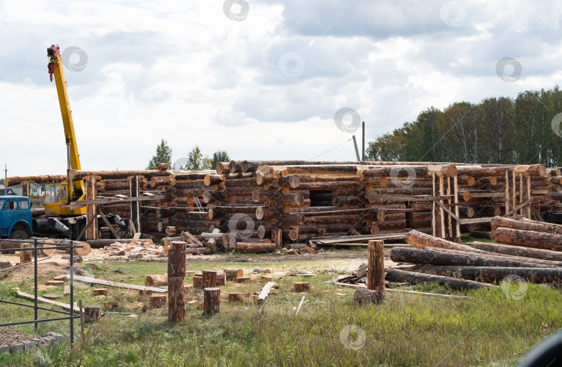 Скачать Строящиеся деревянные дома из сруба с лежащими поблизости строительными материалами фотосток Ozero