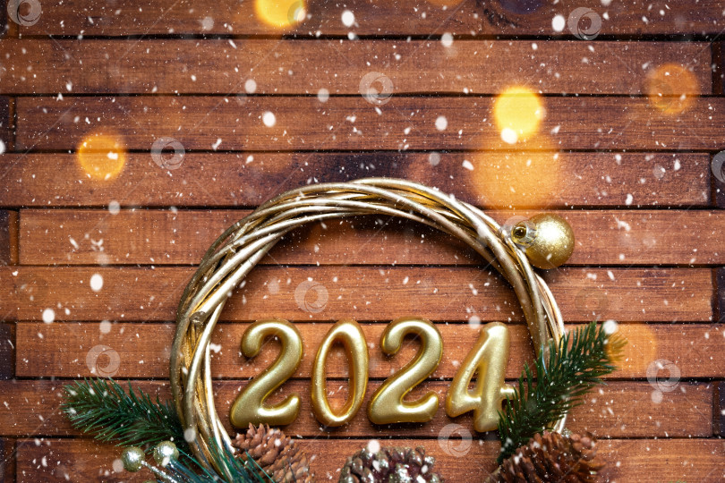 Скачать Деревянные цифры с Новым годом 2024 на уютном праздничном коричневом деревянном фоне с блестками, снегом, огнями гирлянд. Поздравления, открытка. Календарь, обложка фотосток Ozero