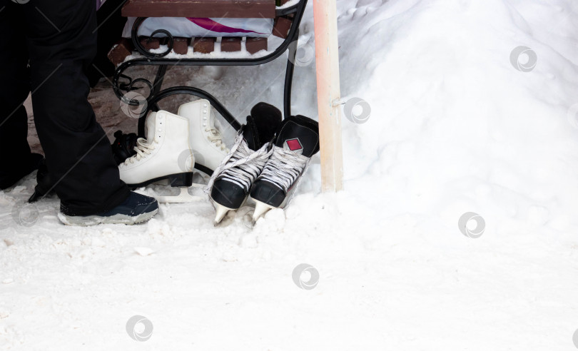Скачать На белом снегу рядом со скамейкой лежат фигурные коньки.Концепция здорового образа жизни зимой. Место для вашего текста фотосток Ozero