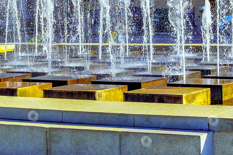 Скачать Брызги воды из уличного фонтана в селективном фокусе на площади Ленина в Астрахани в жаркую погоду. фотосток Ozero