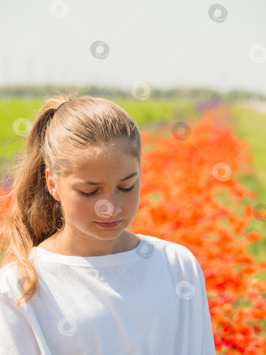 Скачать Портрет красивой задумчивой девушки, гуляющей на свежем воздухе, по весеннему цветочному полю.  Девочка-подросток с опущенной головой, освещенная солнцем, думает о чем-то на цветочном лугу фотосток Ozero