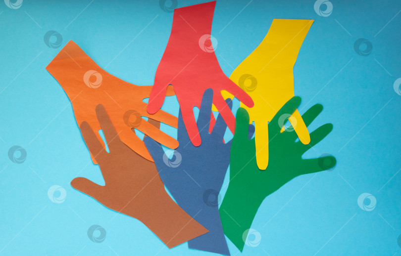 Скачать Абстрактный фон открытые разноцветные бумажные ладони на синем фоне.Концепция Дня борьбы с аутизмом и Дня солидарности молодежи фотосток Ozero