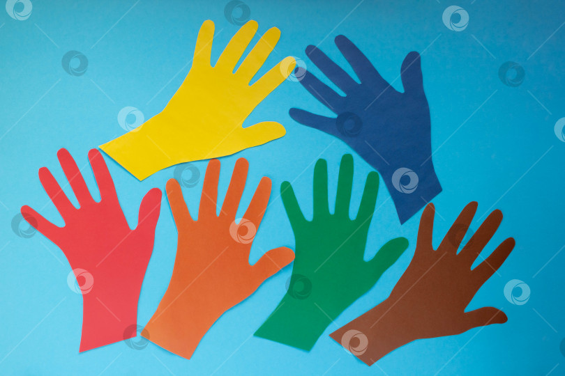 Скачать Абстрактный фон открытые разноцветные бумажные ладони на синем фоне.Концепция Дня аутизма и Дня солидарности молодежи фотосток Ozero