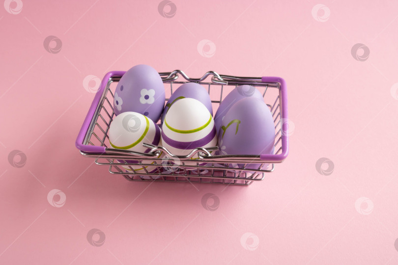 Скачать Металлическая корзина для покупок с сиреневыми куриными яйцами на розовом фоне. Диетический свежий продукт. Концепция Пасхи фотосток Ozero