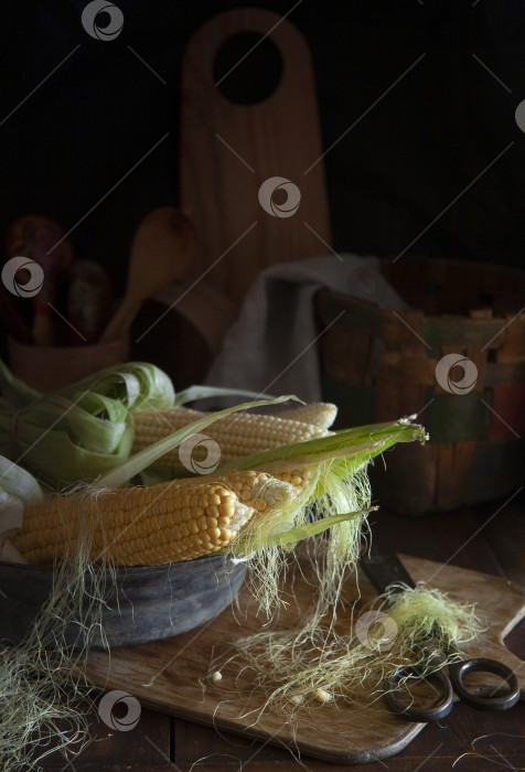 Скачать Кукурузные початки на старинной медной тарелке на фермерской кухне фотосток Ozero