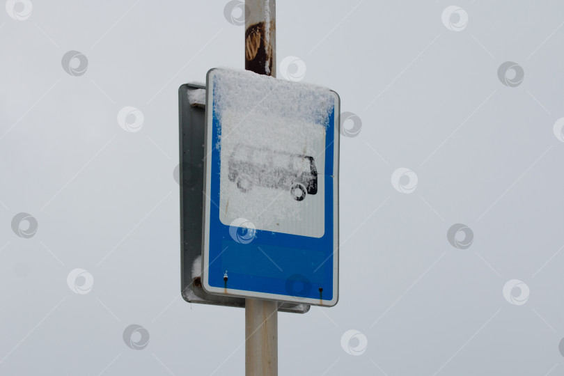 Скачать Дорожный знак автобусной остановки занесен снегом фотосток Ozero