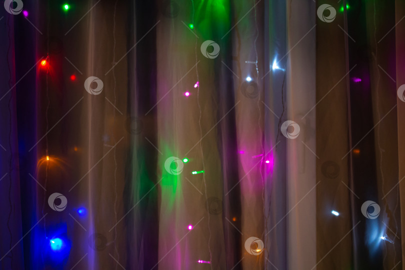 Скачать Праздничная разноцветная занавеска гирлянда огней у окна фотосток Ozero