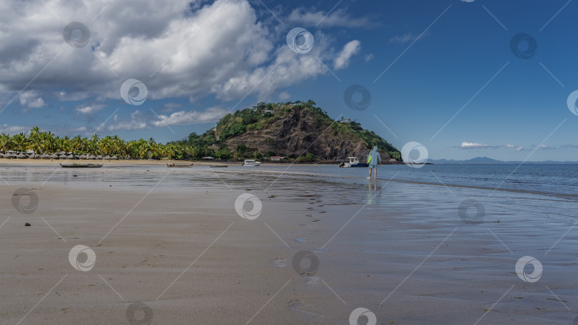 Скачать Мужчина идет по пляжу у кромки воды. фотосток Ozero