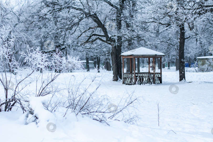 Скачать Деревянная беседка в заснеженном парке. фотосток Ozero