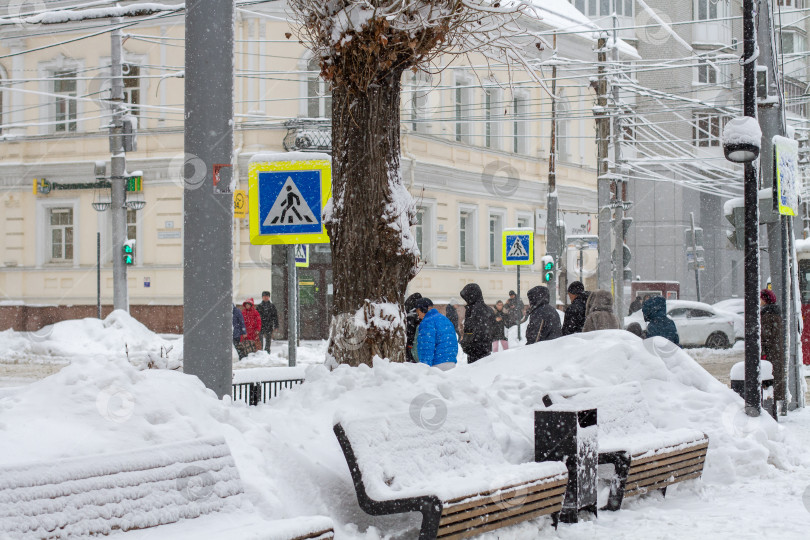 Скачать Люди переходят дорогу в снегопад. фотосток Ozero