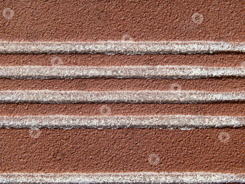 Скачать Фоновая текстура поверхности камня. Белые выпуклые горизонтальные полосы на коричневой зернистой поверхности крупным планом. Макрофотография обратной стороны декоративной плитки фотосток Ozero