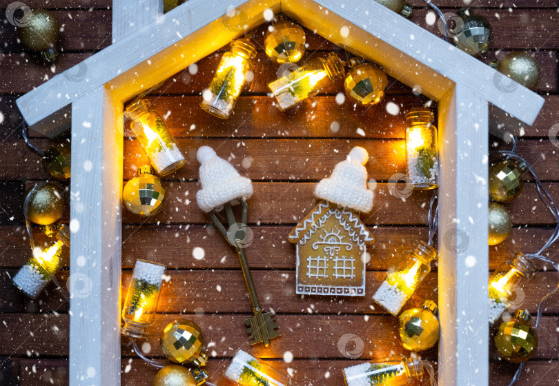 Скачать Ключ от дома с брелком крошечный домик на деревянном фоне с рождественским декором. Подарок на Новый год, Рождество. Строительство, проект, переезд в новый дом, ипотека, аренда и покупка недвижимости фотосток Ozero