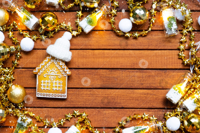 Скачать Крошечный пряничный домик на деревянном фоне с рождественским декором, макетом и копировальным пространством. Подарок на Новый год, Рождество. Строительство, проект, переезд в новый дом, ипотека, аренда и покупка недвижимости фотосток Ozero