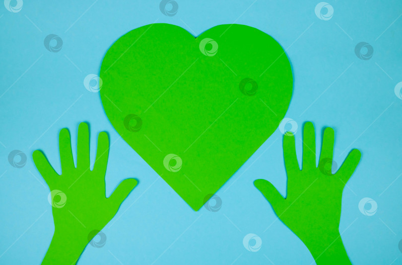 Скачать Бумажно-зеленые руки поддерживают бумажно-зеленое сердце. Концепция охраны окружающей среды фотосток Ozero