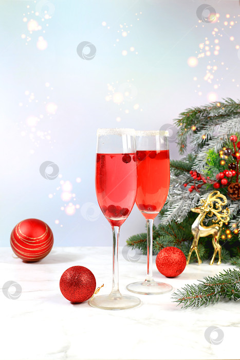 Скачать Рождественский алкогольный коктейль с красным шампанским "Мимоза с клюквой" в бокалах на праздничном фоне с еловыми ветками и украшениями, концепция бара, алкогольные напитки на вечеринке, фотосток Ozero