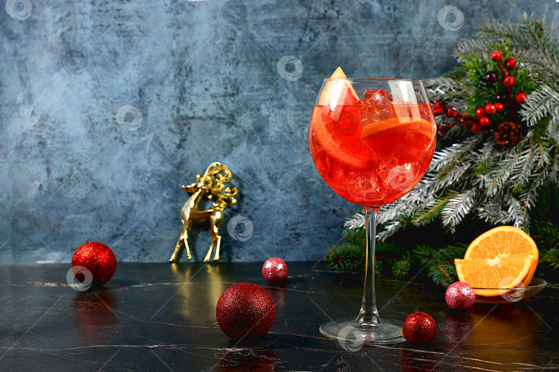 Скачать Рождественский алкогольный коктейль Aperol spritz в бокалах на праздничном фоне с еловыми ветками и украшениями, концепция бара и канун нового года, алкогольные напитки на вечеринке, фотосток Ozero
