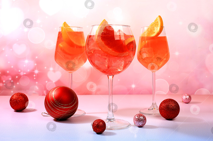 Скачать Рождественский алкогольный коктейль Aperol spritz в бокалах на праздничном фоне с еловыми ветками и украшениями, концепция бара и канун нового года, алкогольные напитки на вечеринке, фотосток Ozero