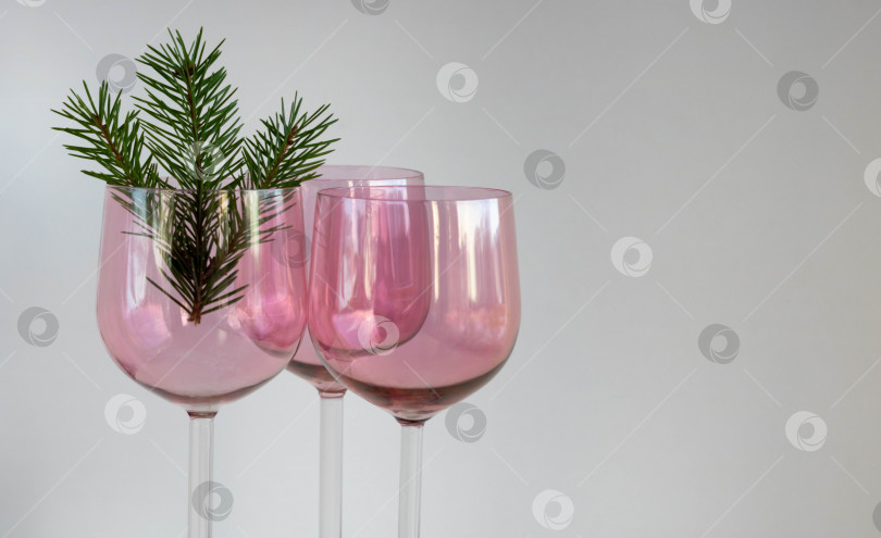 Скачать Три винтажных бокала для вина из розового стекла с еловой веточкой на белом фоне. Концепция Рождества и Нового года фотосток Ozero
