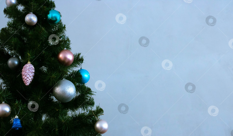 Скачать Праздничный фон для нового года. Рождественская елка на фоне голубой стены фотосток Ozero