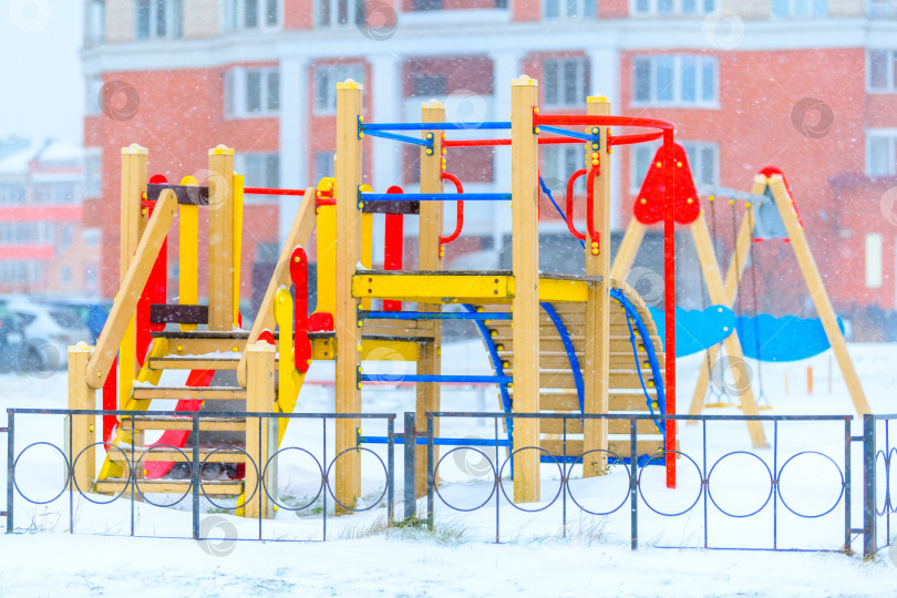 Скачать Детская площадка пустует во время снегопада. Концепция уборки снега муниципальными службами. фотосток Ozero