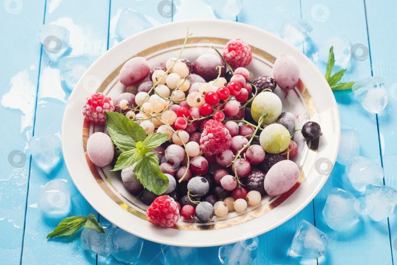 Скачать Замороженные ягоды в тарелке на деревянном столе фотосток Ozero
