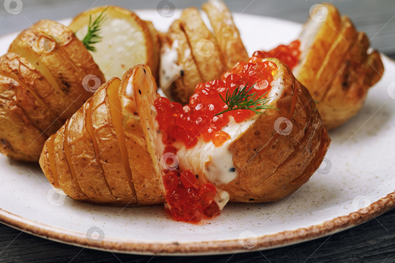 Скачать Запеченный картофель с голландским соусом и красной икрой на тарелке, крупным планом фотосток Ozero