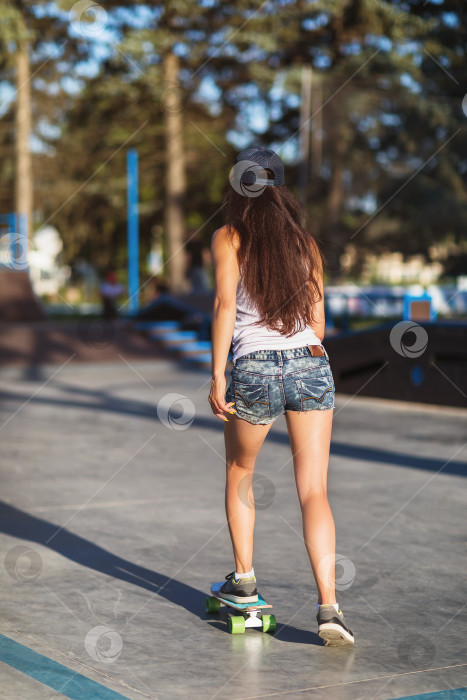 Скачать Девушка катается на скейтборде летним солнечным вечером фотосток Ozero