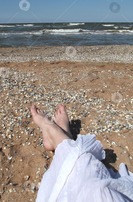 Скачать Женские ноги на песчаном морском пляже. Девушка в белой юбке на диком пляже. фотосток Ozero