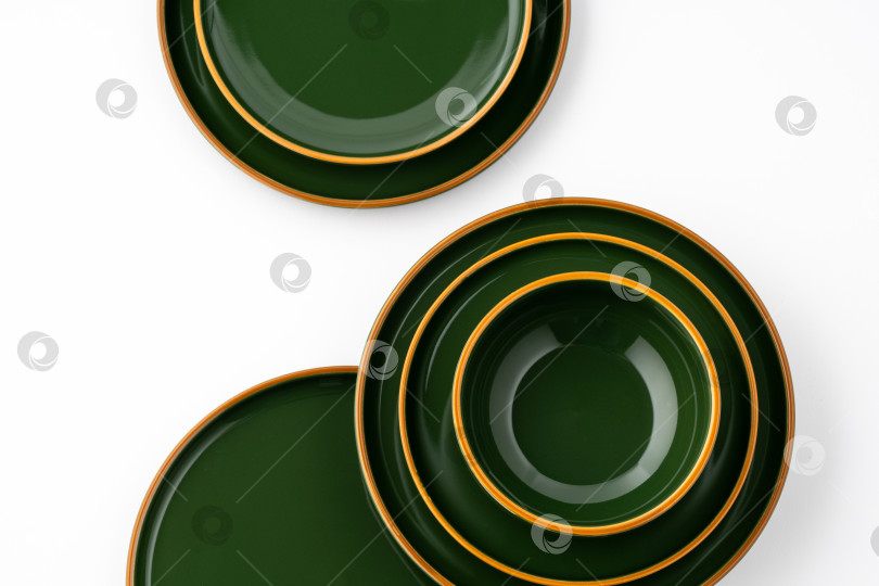 Скачать Набор зеленых керамических тарелок и мисок на белом фоне. Вид сверху фотосток Ozero