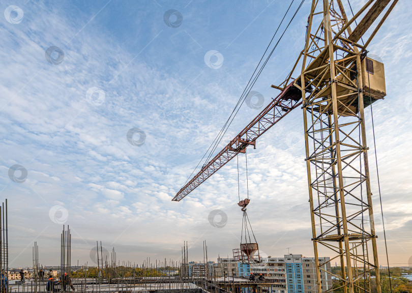 Скачать Снимок крана с оборудованием под низким углом на строительной площадке рядом с инфраструктурой нового здания фотосток Ozero