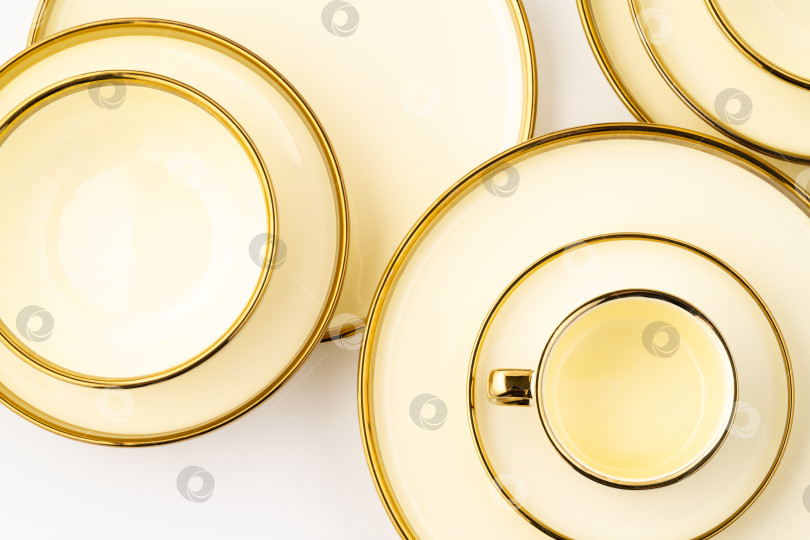 Скачать Набор роскошных керамических кухонных принадлежностей золотистого цвета на белом фоне фотосток Ozero
