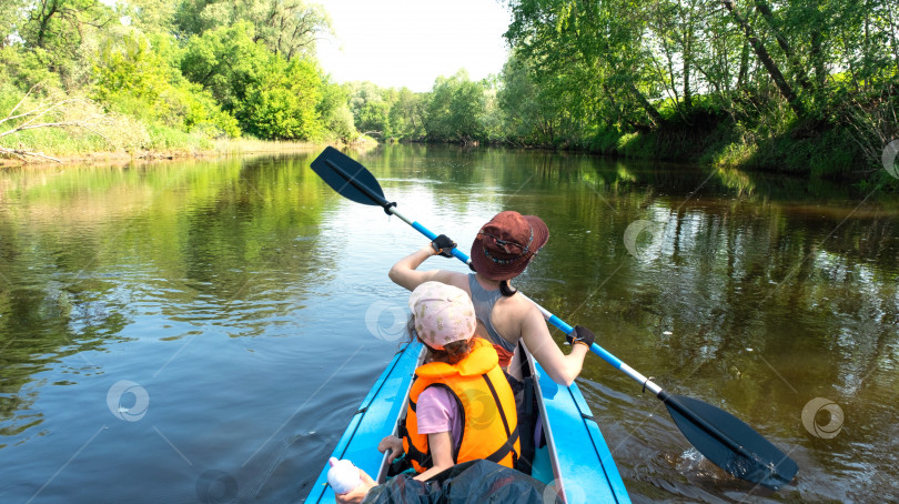 Скачать Семейное путешествие на байдарках. Мама и дочь катаются на лодке по реке, водный поход, летнее приключение. Экологичный и экстремальный туризм, активный и здоровый образ жизни фотосток Ozero