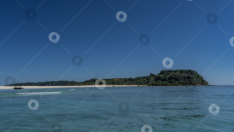 Скачать Красивый тропический остров с зеленой растительностью и белым песчаным пляжем. фотосток Ozero