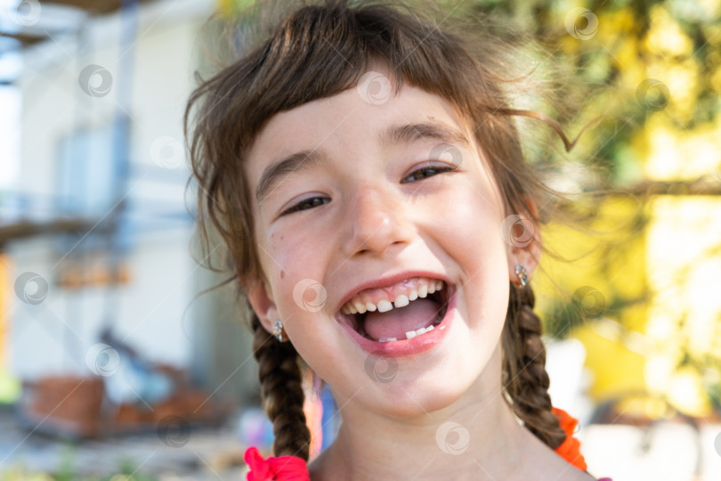 Скачать Беззубая счастливая улыбка девушки с выпавшим нижним молочным зубом крупным планом. Замена зубов на коренные в детстве фотосток Ozero