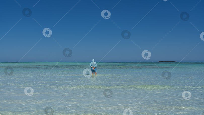 Скачать Человек стоит в бескрайнем аквамариновом океане фотосток Ozero