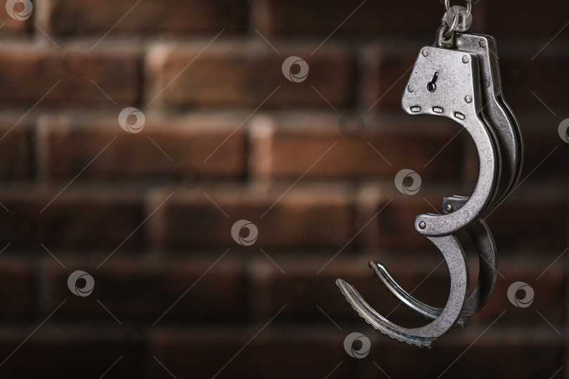Скачать Открытые наручники на фоне кирпичной стены с копией пространства. Концепция: Цена свободы фотосток Ozero