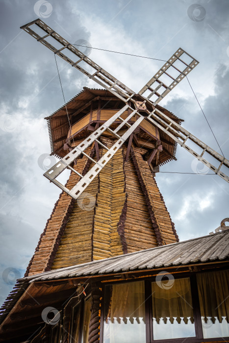Скачать Ветряная мельница. Большая деревянная мельница на фоне облачного неба. фотосток Ozero