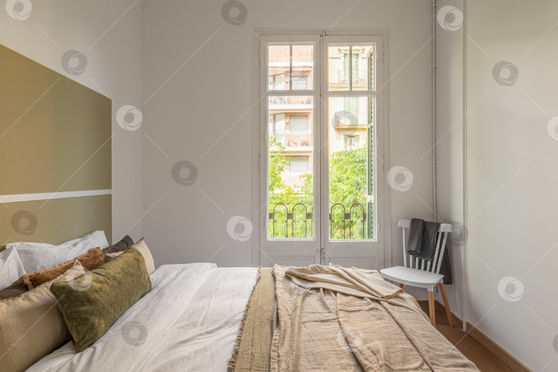 Скачать Светлая и просторная спальня с залитым солнцем окном и уютной мебелью фотосток Ozero