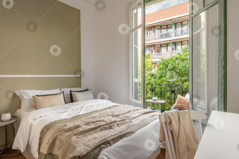 Скачать Шикарная двуспальная кровать на фоне открытого окна с видом на солнечную летнюю погоду. Концепция гостиничного номера для новобрачных. Copyspace фотосток Ozero