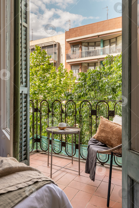 Скачать Городской оазис: Великолепный жилой дом с видом на горизонт, балконом и уютной садовой мебелью в Барселоне фотосток Ozero